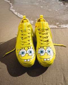 Phenom Elite SpongeBob football cleat lifestyle photo — athlete wearing yellow cleats on field