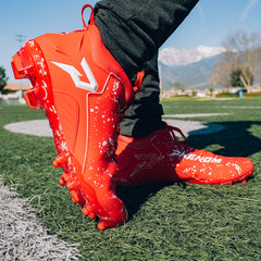 Phenom Elite Kool-Aid Cherry football cleat lifestyle photo — cleats with packet