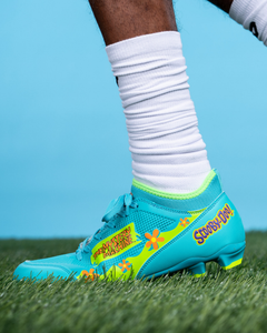 Phenom Elite Scooby-Doo football cleat lifestyle photo — athlete wearing Mystery Machine cleats